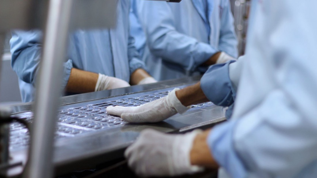 Workers on a pharmaceutical blister packaging line